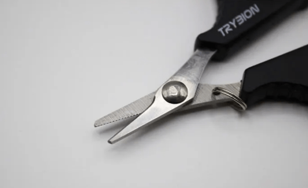 Tijeras TRYBION de 63x94 mm con hoja dentada de acero inoxidable, ideales para cortes limpios y fáciles en monofilamento y trenzados de pesca.